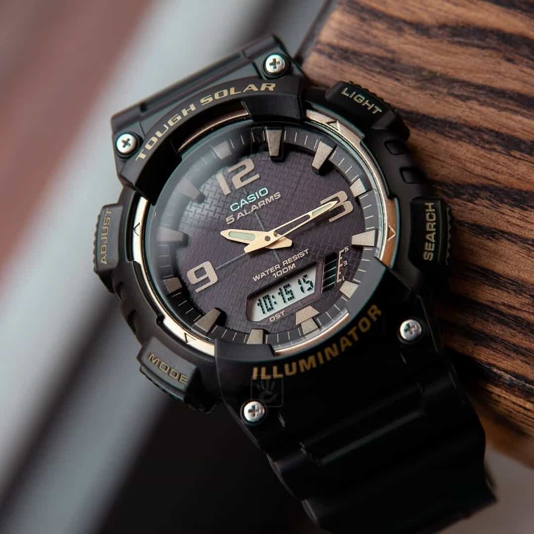 Krupni plan muškog ručnog sata Casio Tough Solar AQ-S810W-1A3VDF, koji naglašava zlatno-crni brojčanik i digitalni zaslon.