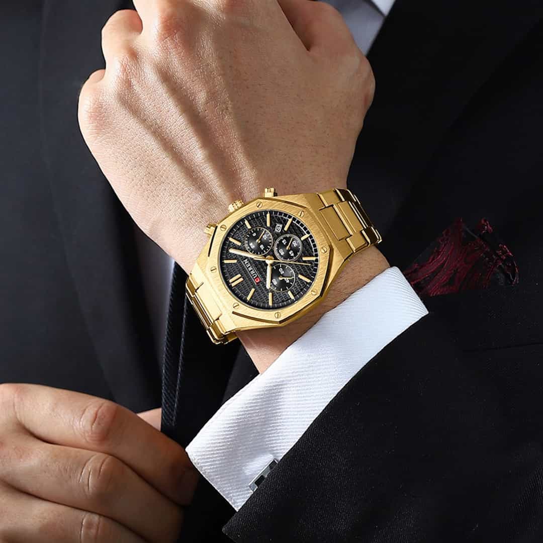 Moška ročna ura Curren Royal Gold/Black na moškem zapestju v elegantni poslovni opravi