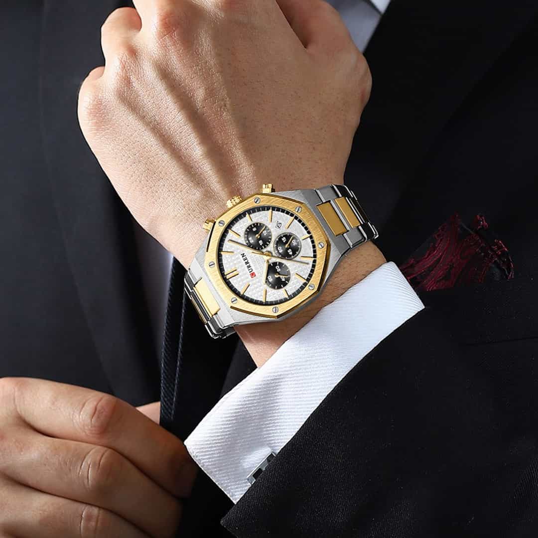 Muški ručni sat Curren Royal Gold/White na muškom zapešću u poslovnom stilu.