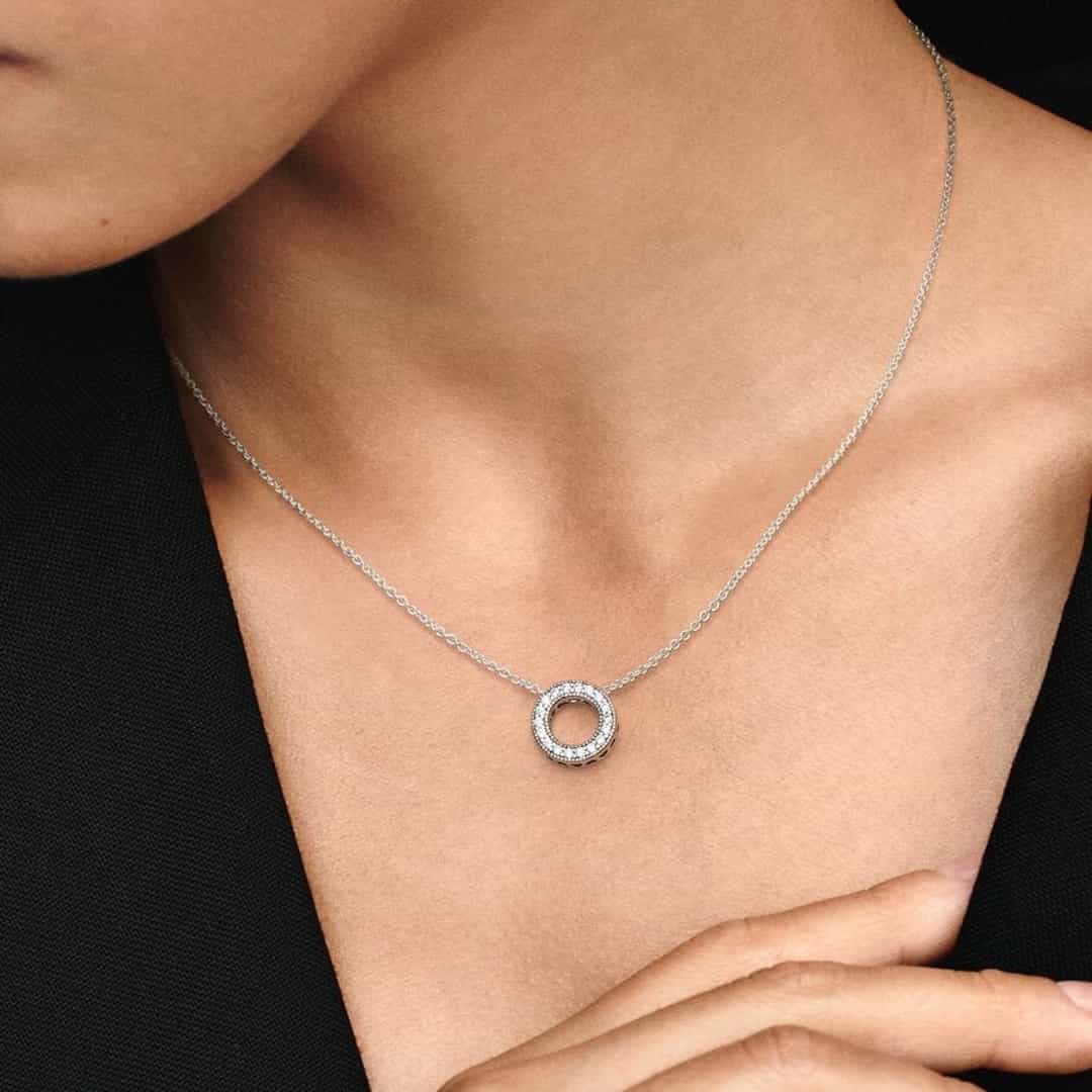 Ženska srebrna ogrlica Pandora Moments 397436CZ-45 s okruglim privjeskom, ukrašena cirkonima, savršeno nadopunjuje crni outfit.