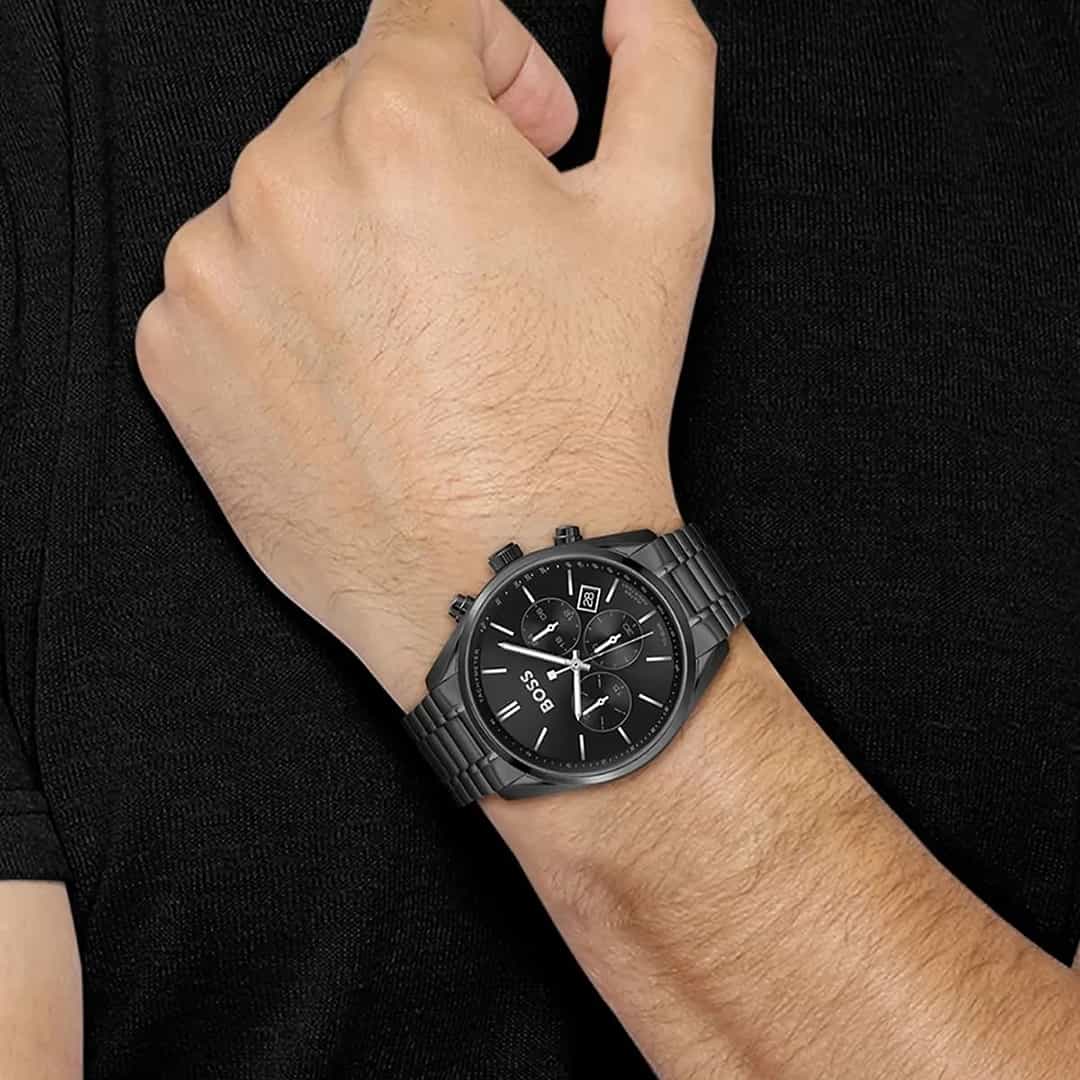 Muški sat Hugo Boss 1513960 na zapešću uz crnu majicu, potpuno crni metalni dizajn i kronograf